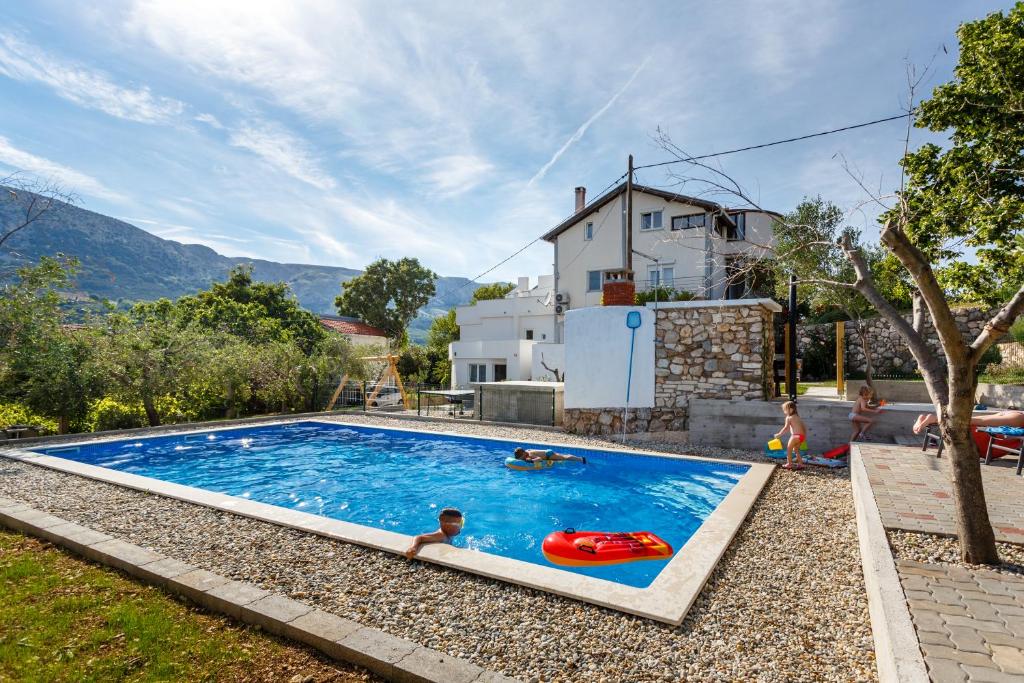 a swimming pool with two people in a house at Apartmani Mihaela II in Baška