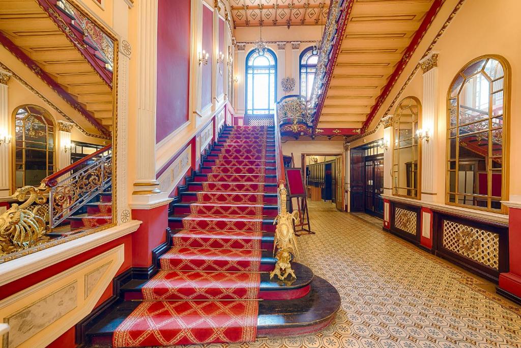 una escalera de caracol en un edificio con escalones rojos en Focus Hotel Premium Pod Orłem en Bydgoszcz