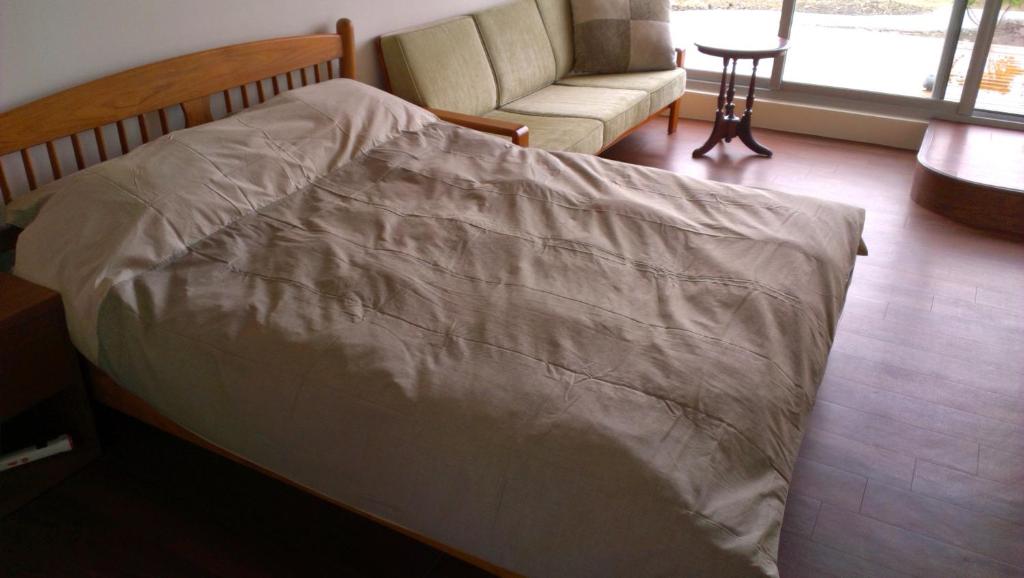 a bed in a room with a chair and a couch at Pretty Dulan B&B in Donghe
