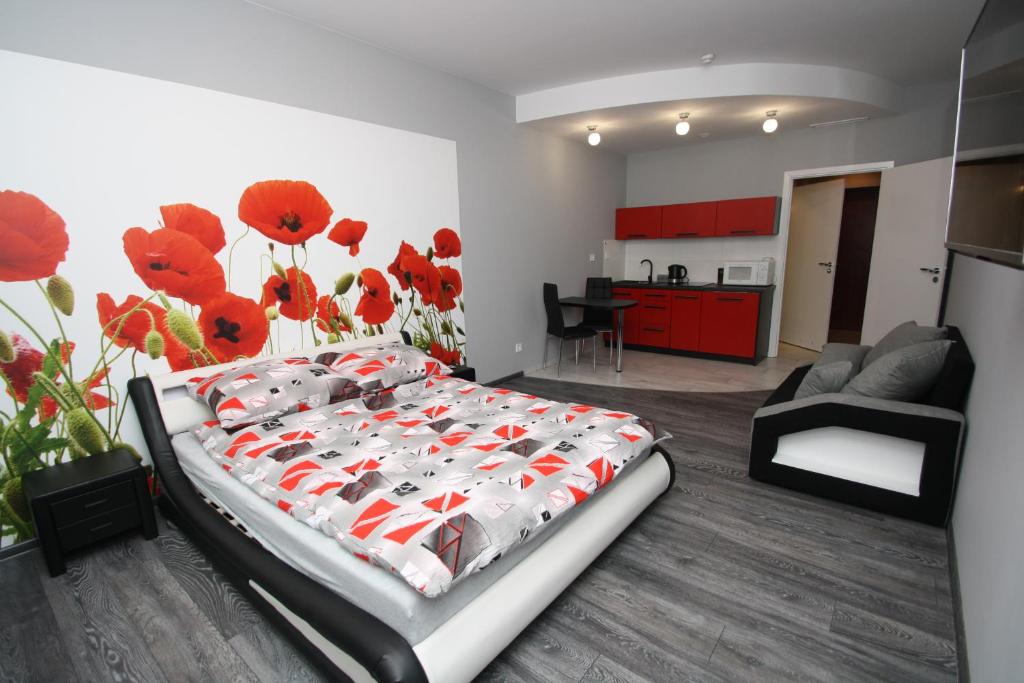 コウォブジェクにあるPoppy Apartment Kolobrzegのベッドルーム1室(赤い花の壁にベッド1台付)