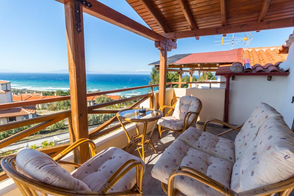 a balcony with chairs and a table and the ocean at Sunny Poseidi in Possidi
