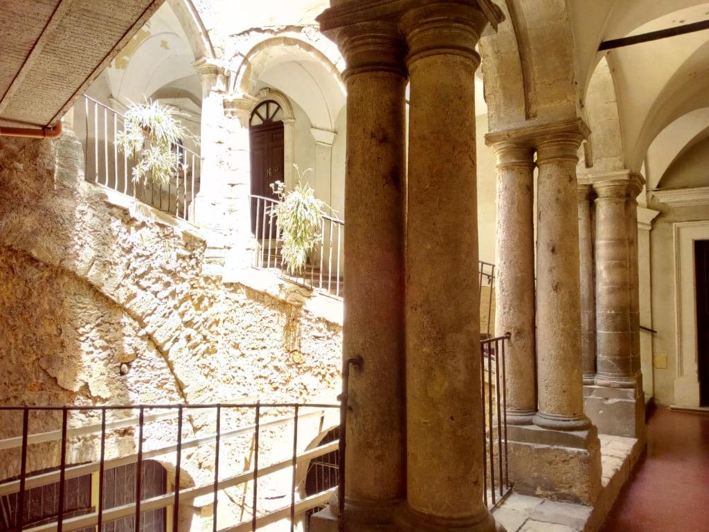 an old building with columns and a wall at Palazzo Aprile in Caltagirone
