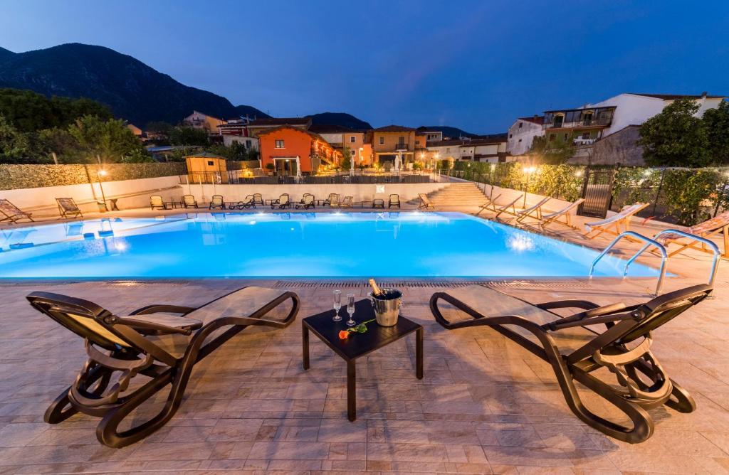 een zwembad met stoelen en een tafel ernaast bij Dolce Vita Relais in Sala Consilina