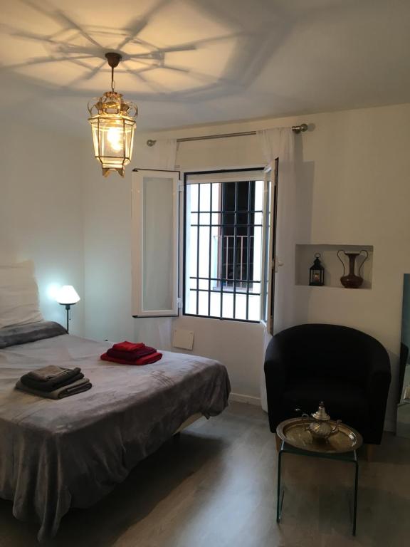 1 dormitorio con 1 cama, 1 silla y 1 ventana en Mezquita Home, en Córdoba