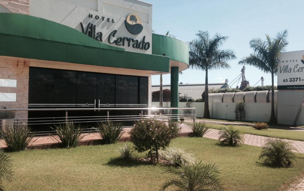 a building with a sign for a mall car dealership at Hotel Villa Cerrado in Nova Mutum