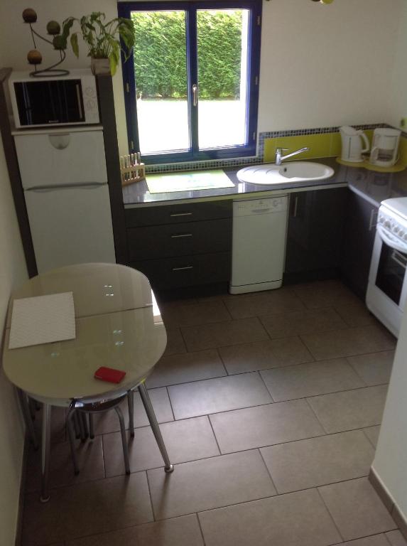 una pequeña cocina con mesa y fregadero en Serenity, en Le Landin
