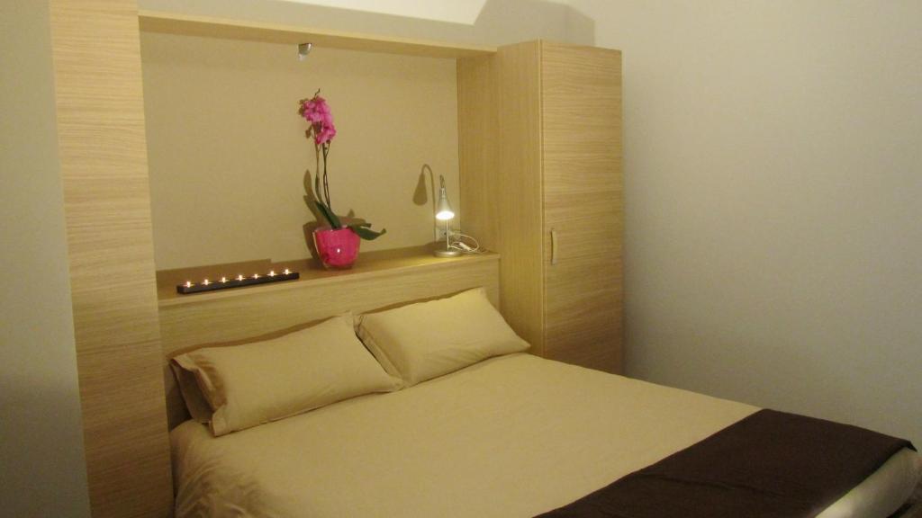 Un pequeño dormitorio con una cama con una planta en un estante en Bar Trattoria Colombina Affittacamere, en Bossico