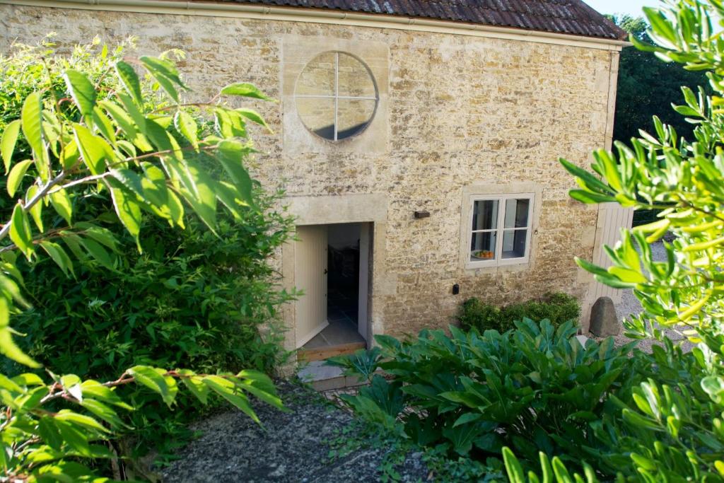 Elle offre une vue extérieure sur un bâtiment en pierre doté d'une porte. dans l'établissement Ivythorpe Coach House, à Bath