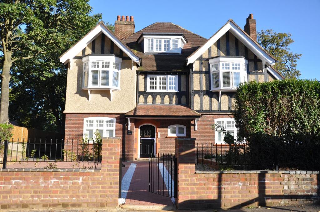 a brick house with a gate and a fence at HomefromHolme Alban House in Saint Albans