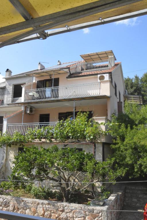 a building with a balcony and trees in front of it at Apartments Bakuk in Stari Grad