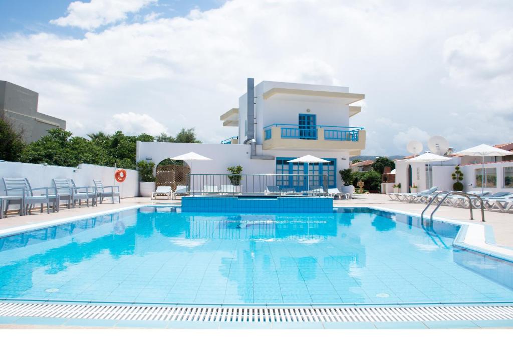 a large swimming pool in front of a building at Kasapakis Hotel & Apartments in Hersonissos