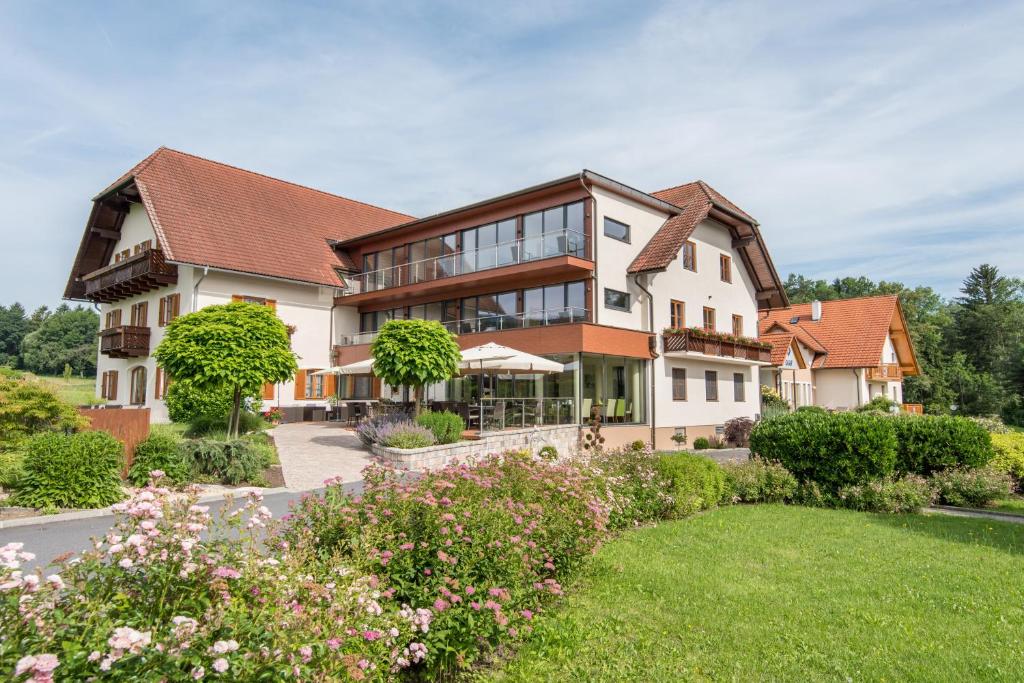 a large house with a garden in front of it at Hotel-Restaurant Gruber in Pöllau