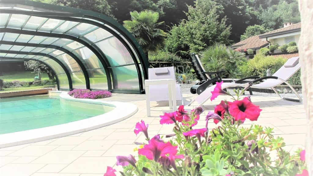 une terrasse avec une piscine, des chaises et des fleurs dans l'établissement Casa Guglielmo, à Pisogne