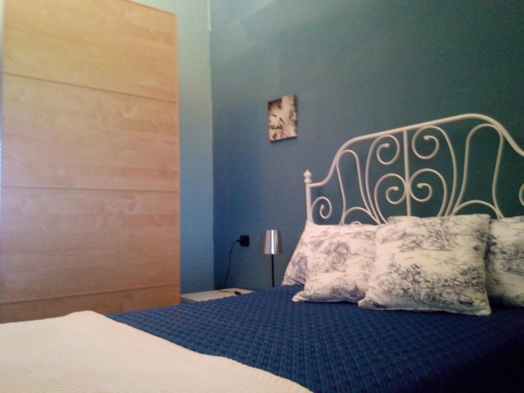 1 dormitorio con 1 cama con pared azul en Il Giardino Di Emilio, en Marrùbiu
