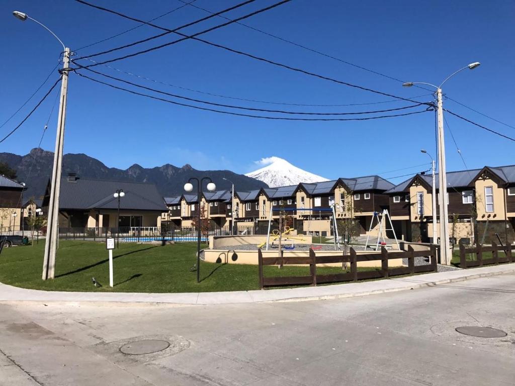 a street with a playground with a mountain in the background at Casa Condominio Los Robles in Pucón