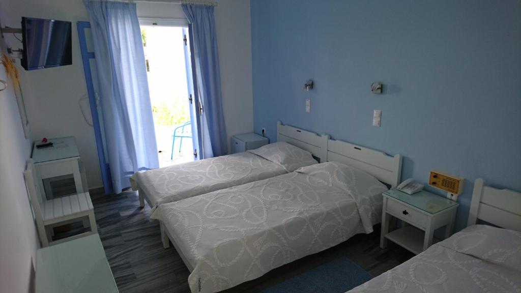 a small bedroom with two beds and a window at Panorama Paros in Parikia