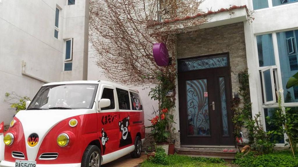 a small red and white car parked in front of a house at Mallorca Homestay in Hualien City