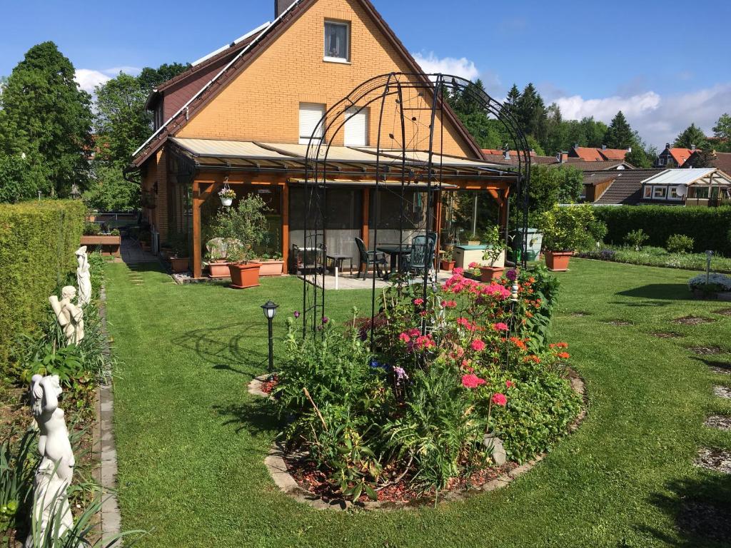 una casa con un jardín con flores en el patio en Oma Hennys Bergnest, en Clausthal-Zellerfeld