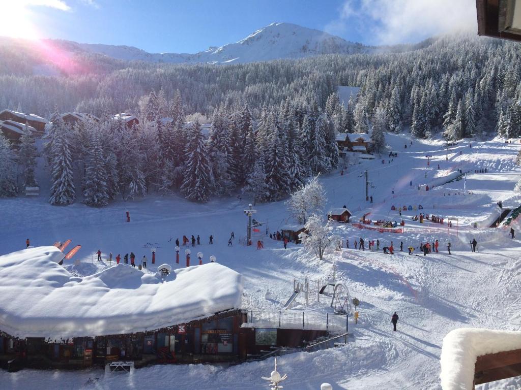 eine Gruppe von Menschen fährt einen schneebedeckten Hang hinunter in der Unterkunft Le Britania 507 in La Tania