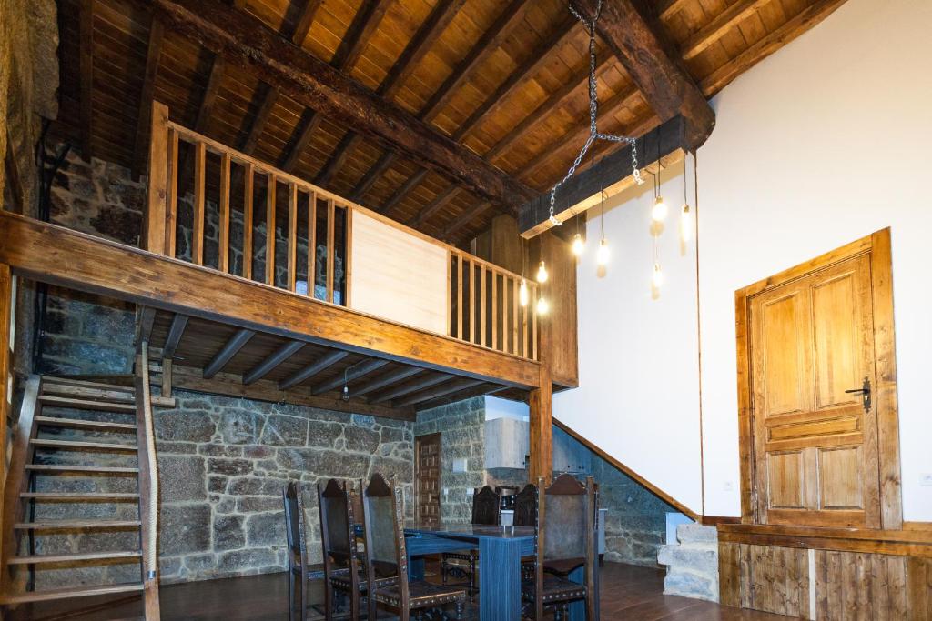 a room with a loft with a table and chairs at Loft Medieval in Ribadavia