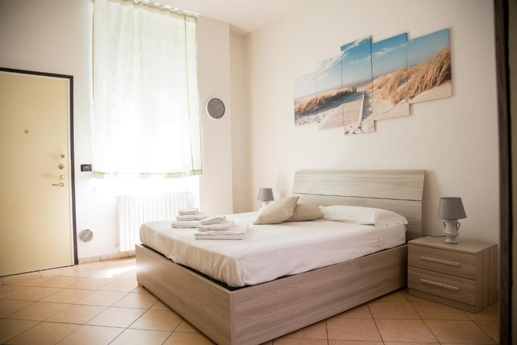 Enjoy Bologna Apartment في بولونيا: غرفة نوم بسرير ونافذة كبيرة
