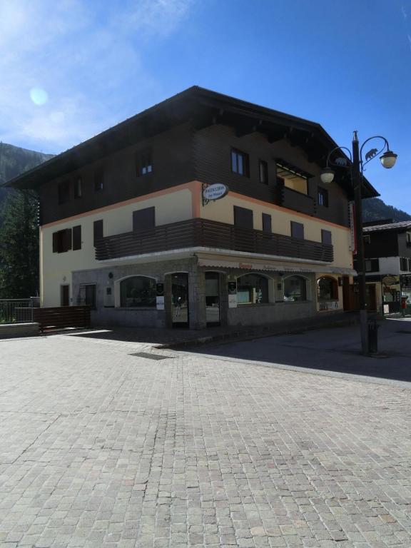 a large building with a brick courtyard in front of it at Alberti Casa Maturi in Madonna di Campiglio