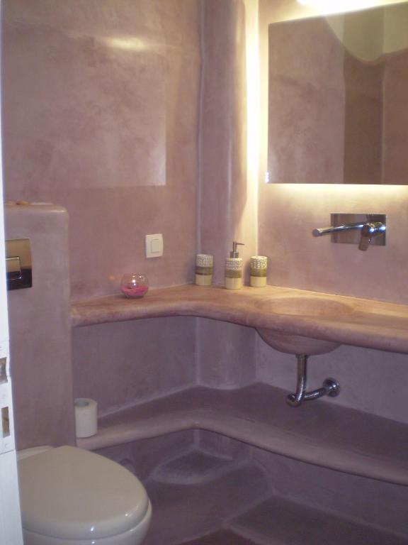 a bathroom with a sink and a toilet and a mirror at Studios Irineos in Perissa
