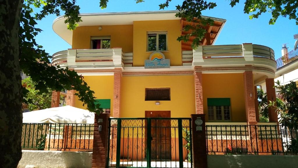 una casa amarilla con una puerta delante de ella en Villa Anna B&B, en Praia a Mare