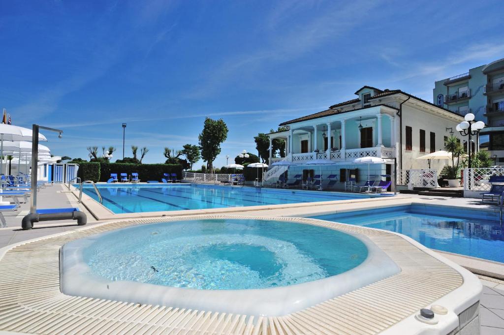 una gran piscina con una gran bañera frente a un edificio en Hotel Venus, en Gabicce Mare