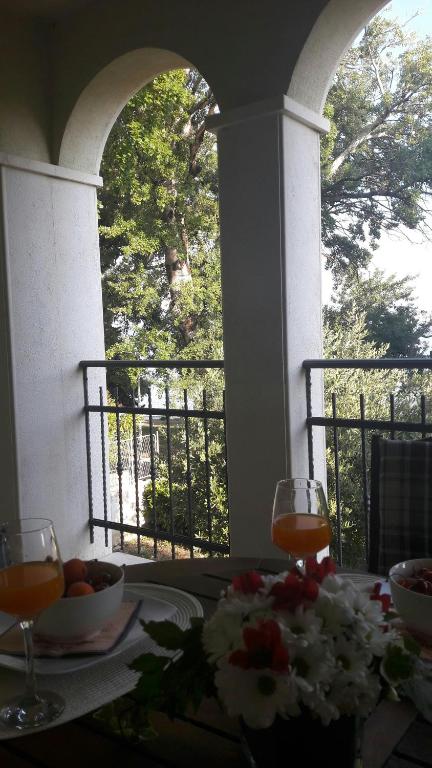 a table with two glasses of wine on a balcony at Apartmani Vitturi in Kaštela