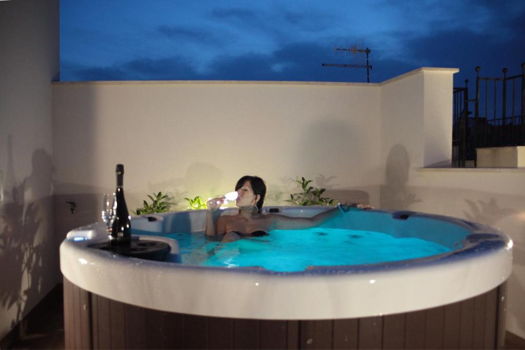a woman in a jacuzzi tub in a building at La Nicchia in San Vito lo Capo