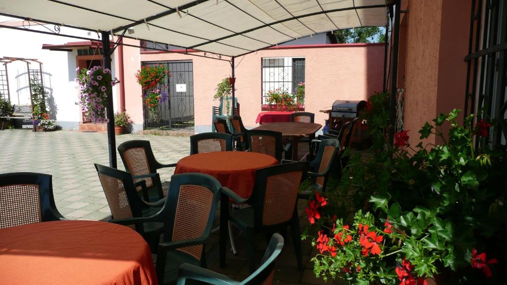 an outdoor patio with tables and chairs and flowers at Penzion Hajský mlýn in Nebanice