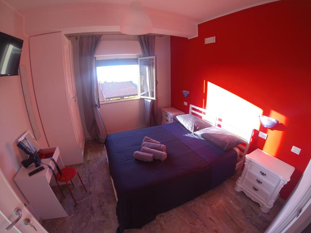 una camera con un letto blu e una parete rossa di A Marina a Scilla