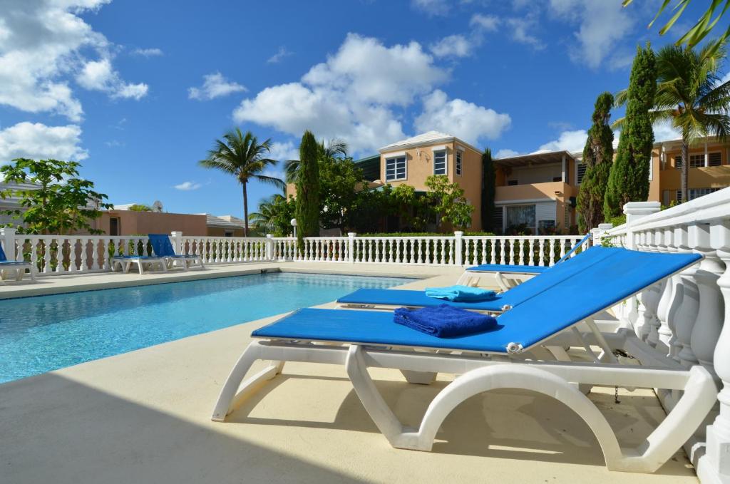 a swimming pool with a blue lounge chair next to a pool at Pelican Pearl in Simpson Bay