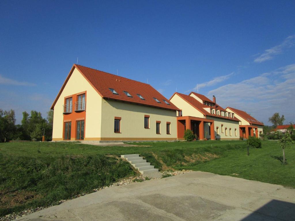 a large house on a grassy field next to a house at Penzion Alma in Znojmo