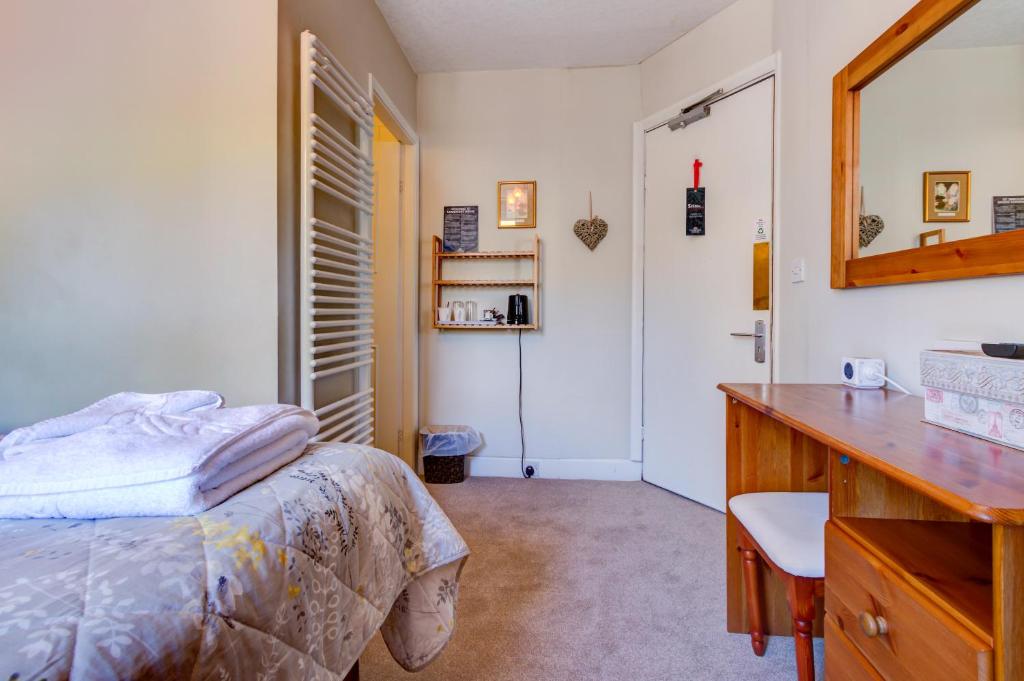 ウィンダミアにあるCambridge House room only accommodation for Adultsのベッドルーム(ベッド1台、デスク、鏡付)