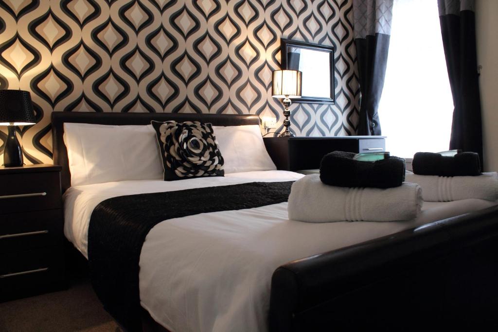 um quarto com duas camas e uma parede com padrões em Bamford House Hotel em Blackpool