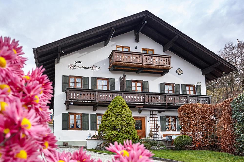 a large white building with a balcony and flowers at Ferienwohnung Graseck in Garmisch-Partenkirchen
