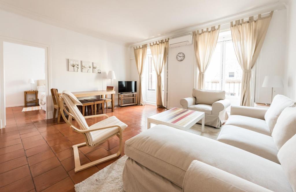 a living room with white furniture and a table at Apartamentos Madrid Centro W in Madrid