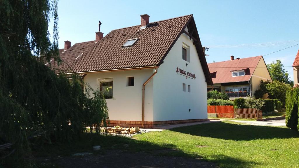 a white house with a brown roof at Pongrácz Apartman in Zirc