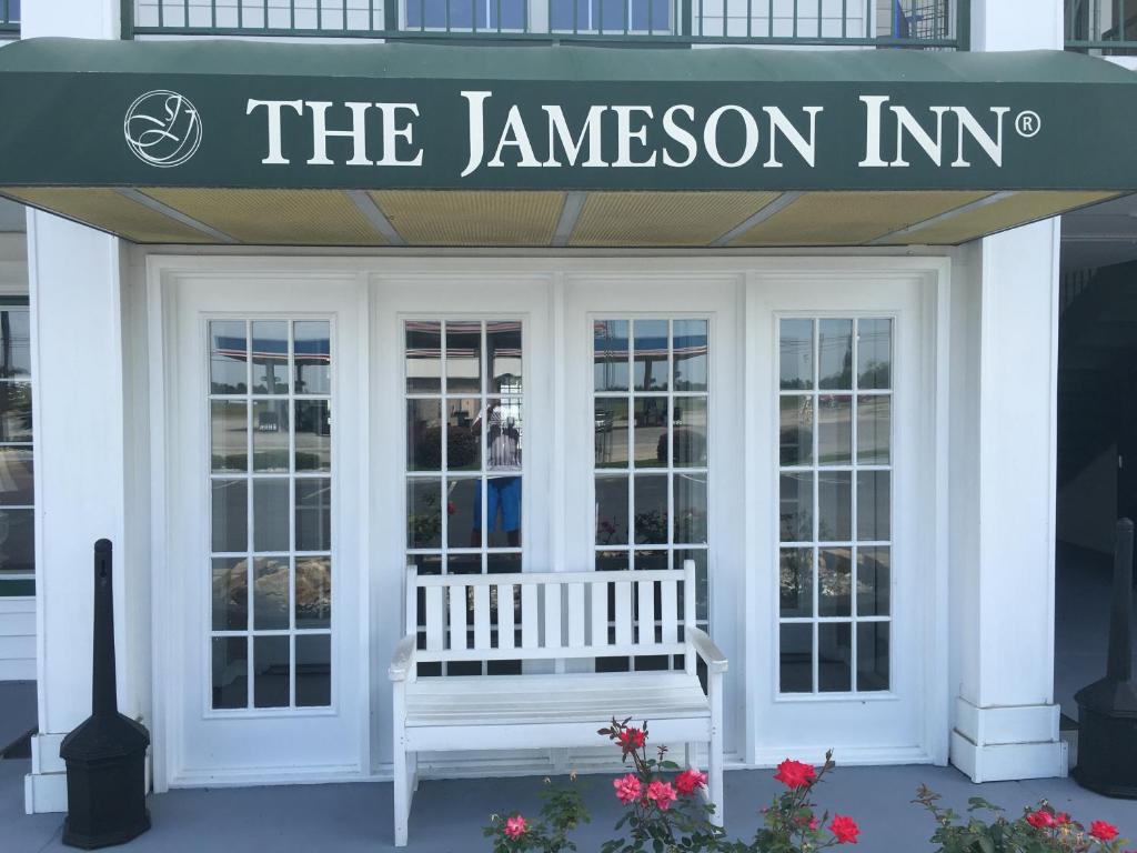 a white bench sitting in front of a jameson inn at Jameson Inn Douglas in Douglas
