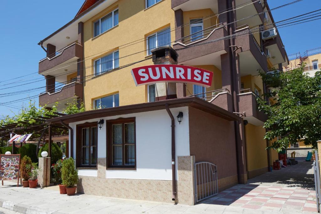 a building with a sun rise sign on it at Hotel Sunrise in Ravda