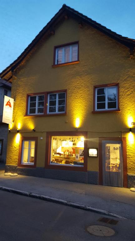 a store front of a building at night at A CÔTE in Môtiers