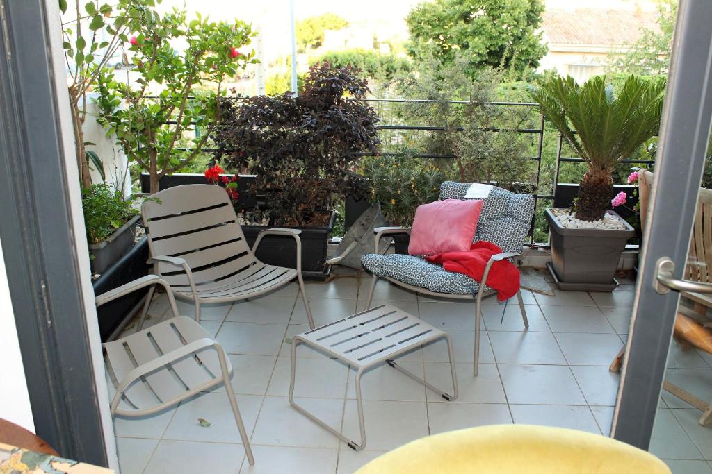 d'un balcon avec des chaises, des tables et des plantes. dans l'établissement Appartement de Louise proche aéroport, à Lucciana