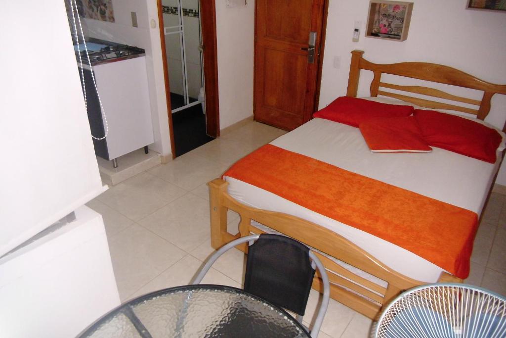 1 dormitorio con 1 cama y algunas sillas y mesas en CYM Arriendos 1605, en Santa Marta