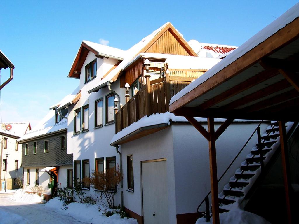 a white building with snow on the side of it at Haus Schammes in Wutha-Farnroda