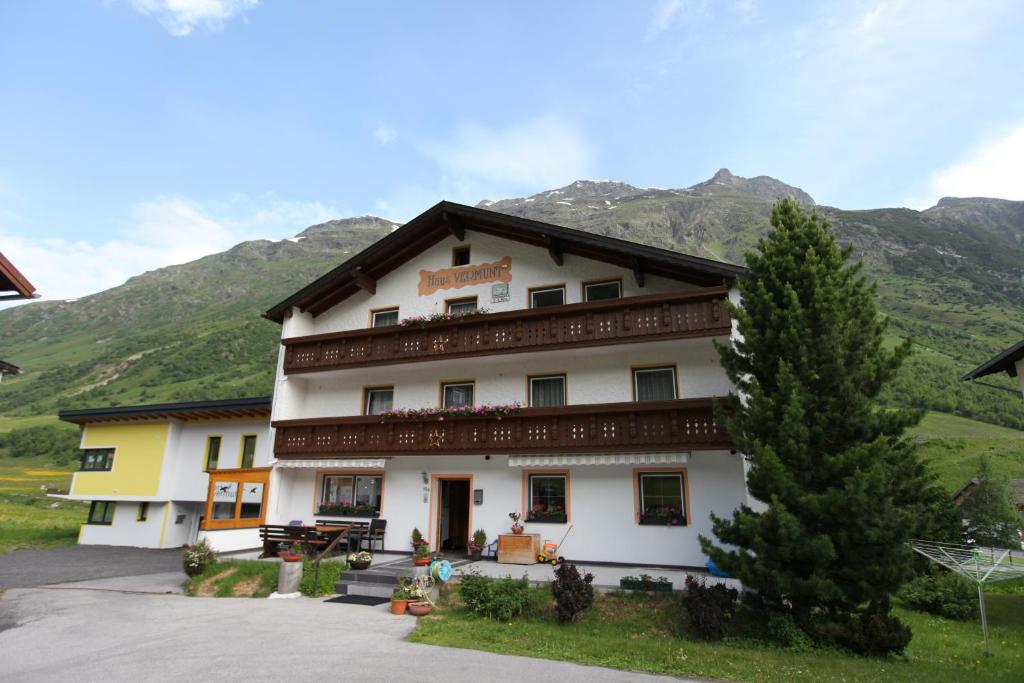 un grande edificio bianco con montagne sullo sfondo di Vermunt 19a a Galtür