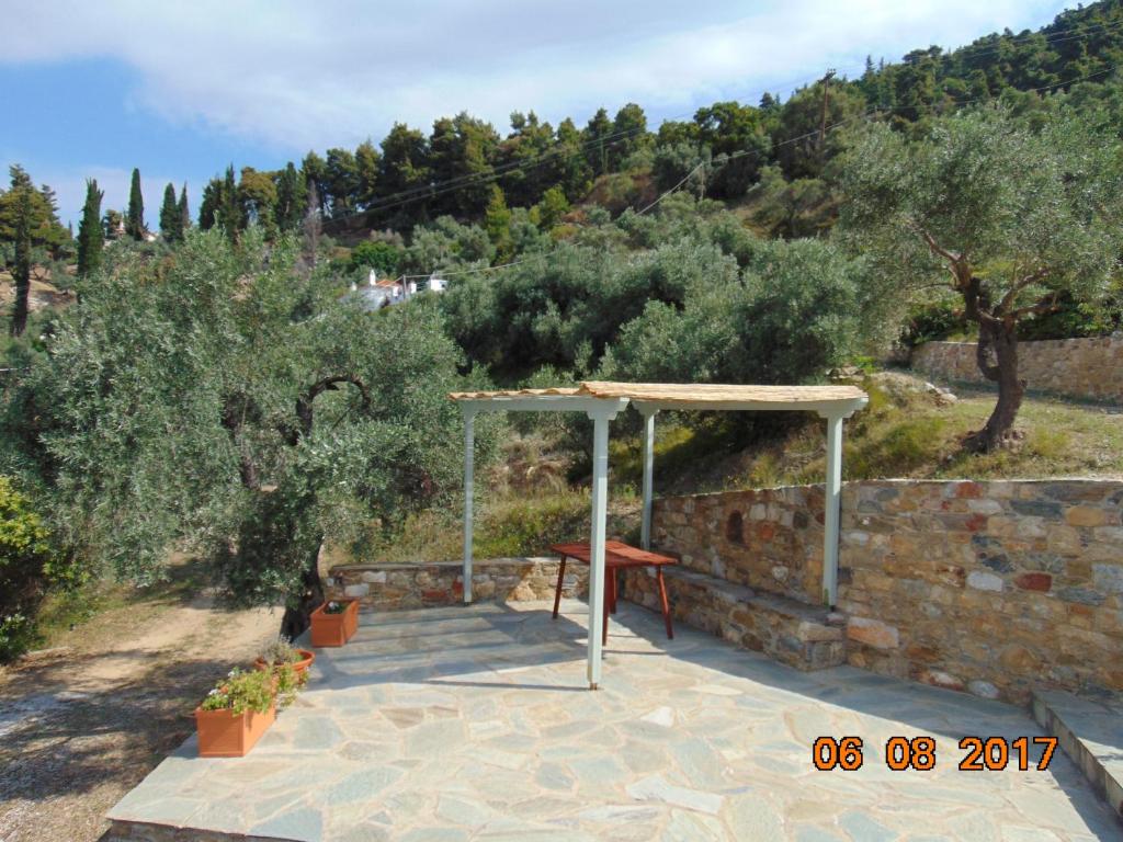 a shelter with a table on a stone wall at Kalithea Studios in Stafylos