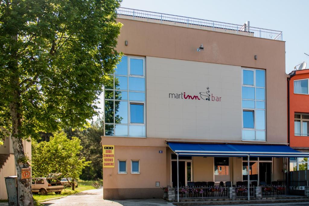 un edificio con un cartel que lee la tienda de la ciudad en Hotel Martin, en Međugorje