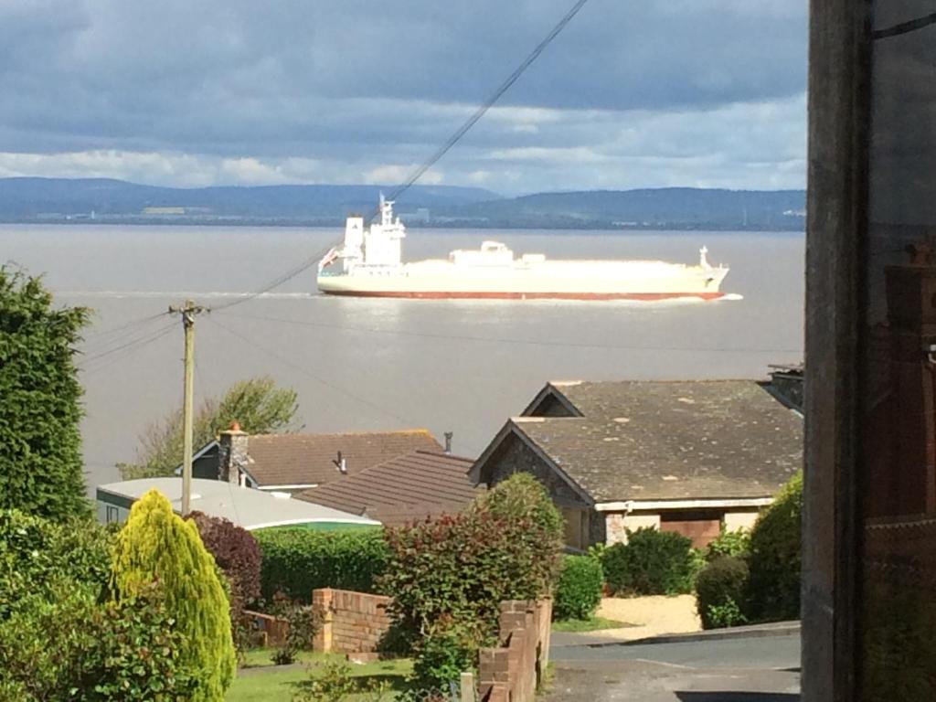 a large white ship in the water with houses at The Nook @ Drop Anchor in Portishead